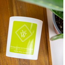 Load image into Gallery viewer, Hand poured soy candle with lime and lemongrass scent, handmade in Ireland by Wix & Wax.White candle jar with green label on a wooden surface.